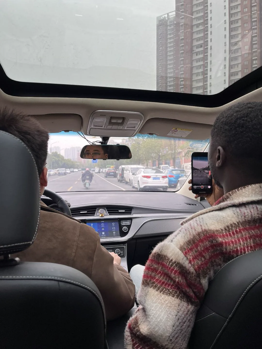 A client reviewing a vehicle interior with the Xincheng Auto team