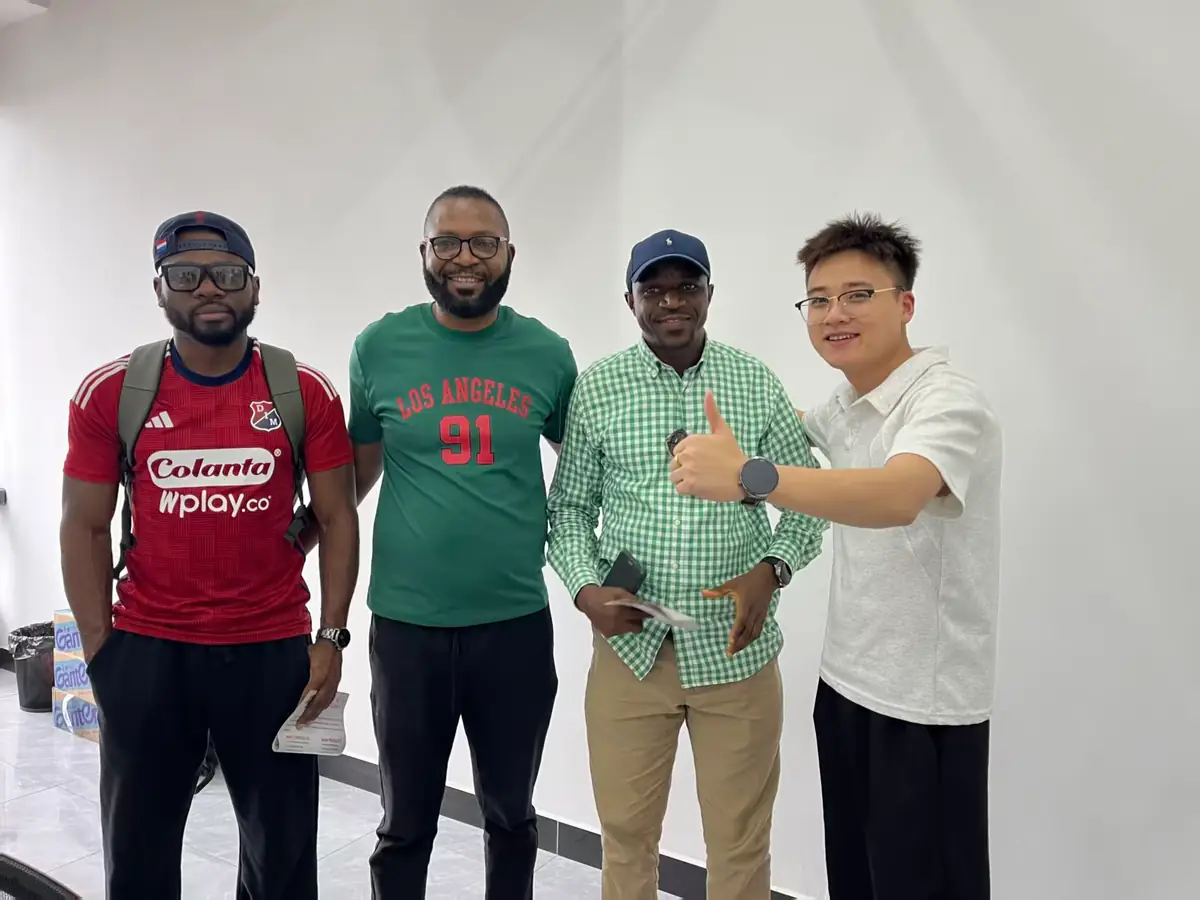 Overseas buyers visiting and posing with the Xincheng Auto team